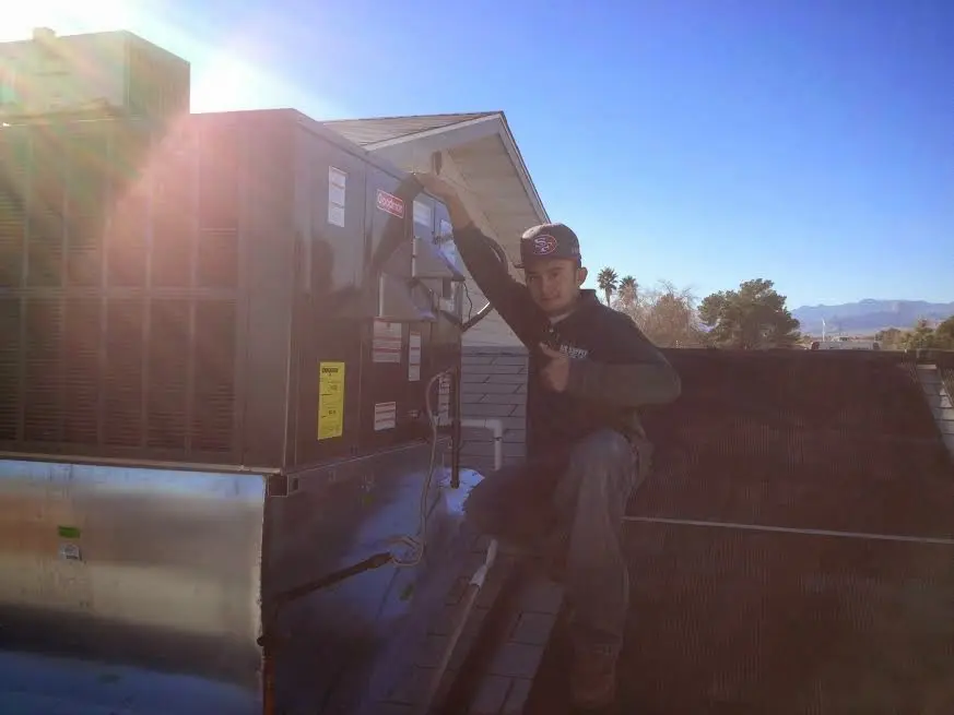HVAC technician performing AC Tune-Up on a rooftop unit in Blue Ash